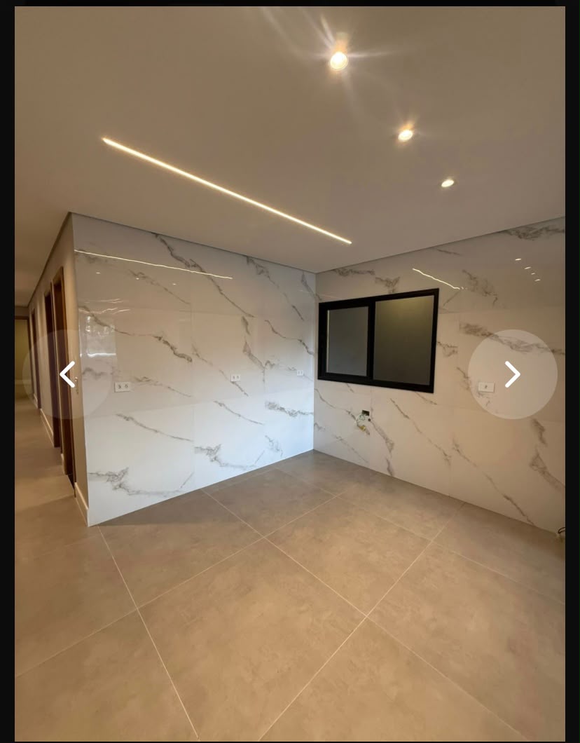 Sala com revestimento marmorizado e iluminação quente